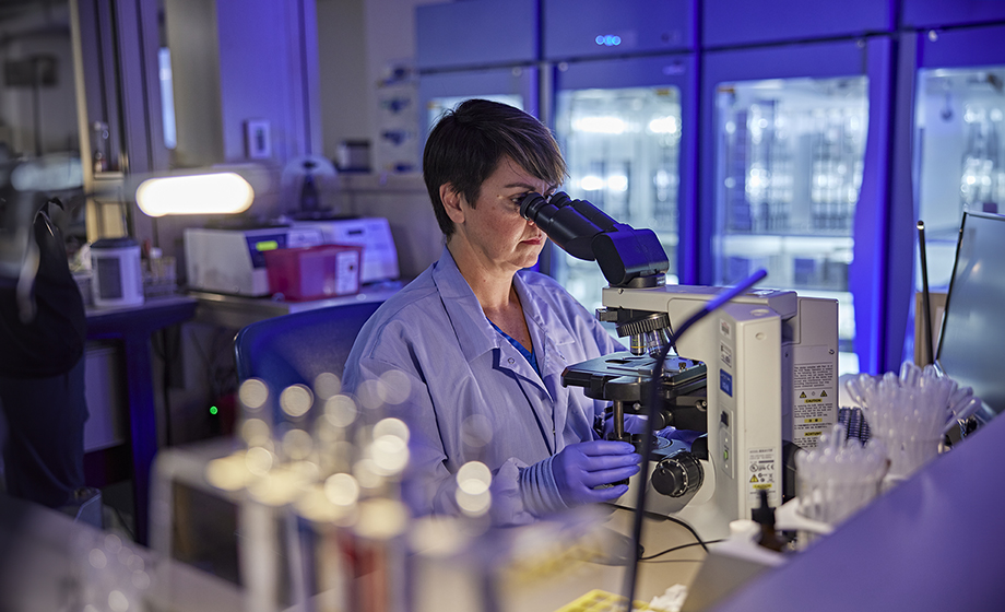 Scientist using microscope