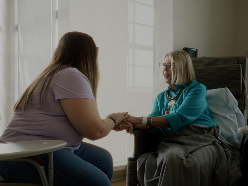 Cancer patient holding hand of caretaker