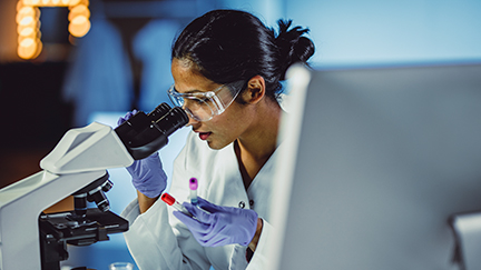 woman looking into microscope