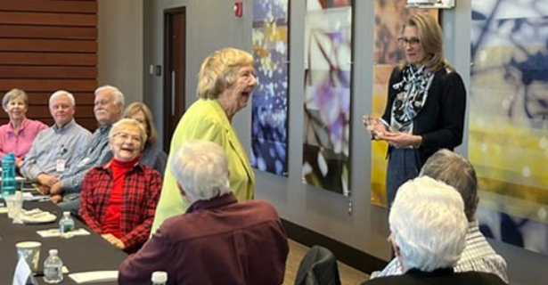 Woman receiving recognition in a room of people